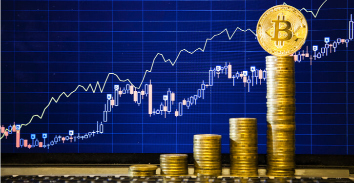 Bitcoin Münzen gestapelt in einer aufsteigenden Reihenfolge vor einem steigenden Chart