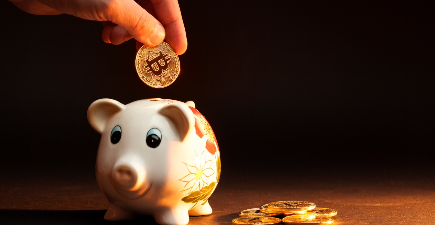 Bild einer Bitcoin, die in einem Sparschwein deponiert wird