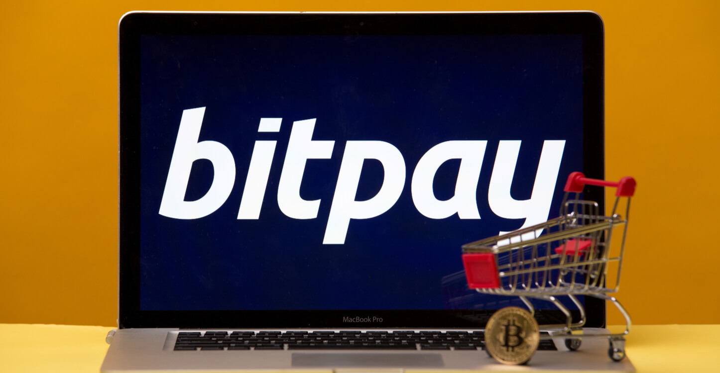 Bild von Mini-Einkaufswagen und Bitcoin auf einem Laptop, auf dem BitPay ausgeführt wird