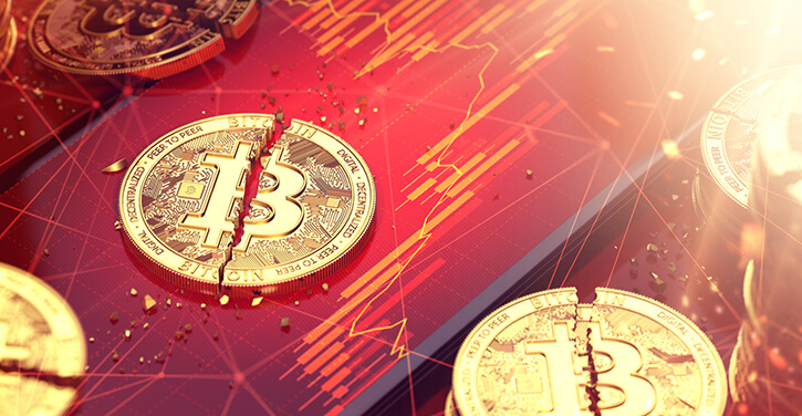 Zerbrochener Bitcoin in zwei Hälften mit rot eingefärbter Marktchart