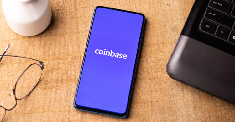 Das Coinbase-Logo auf einem Smartphone auf einem Schreibtisch